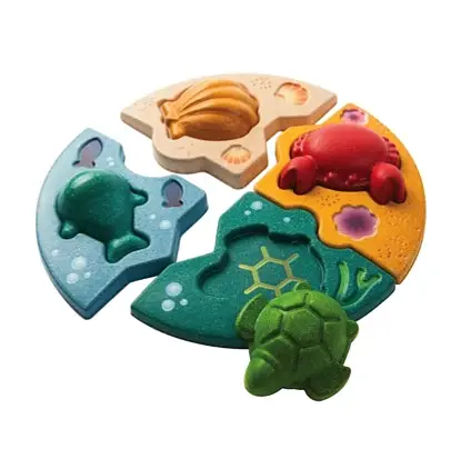 Träpussel med marint tema från PlanToys, innehåller havsdjur som krabba, sköldpadda, val och skal, designat för att främja finmotorik och problemlösning.